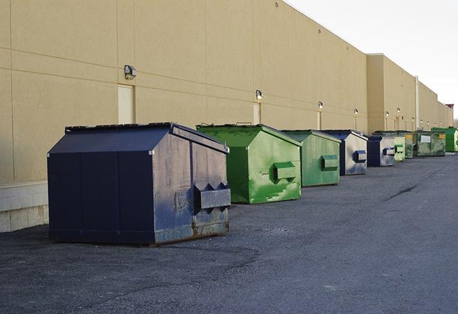 a waste management truck unloading into a construction dumpster in Boaz, AL